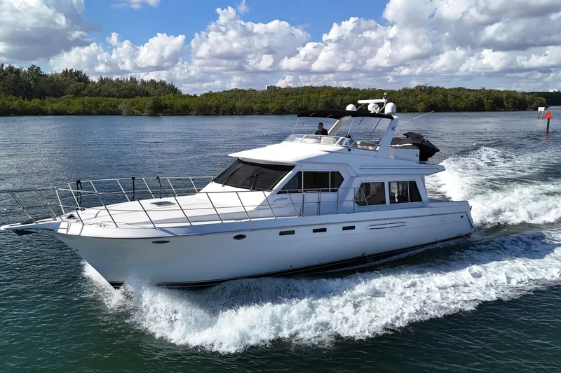 Slide: The Image of 2003 Navigator Rival yacht cruising on a sunny day with lush greenery in the background. - 3