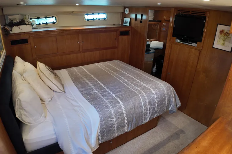 Slide: The Image of Luxurious bedroom interior on 2003 Navigator Rival yacht with cozy bedding and wooden cabinetry. - 33