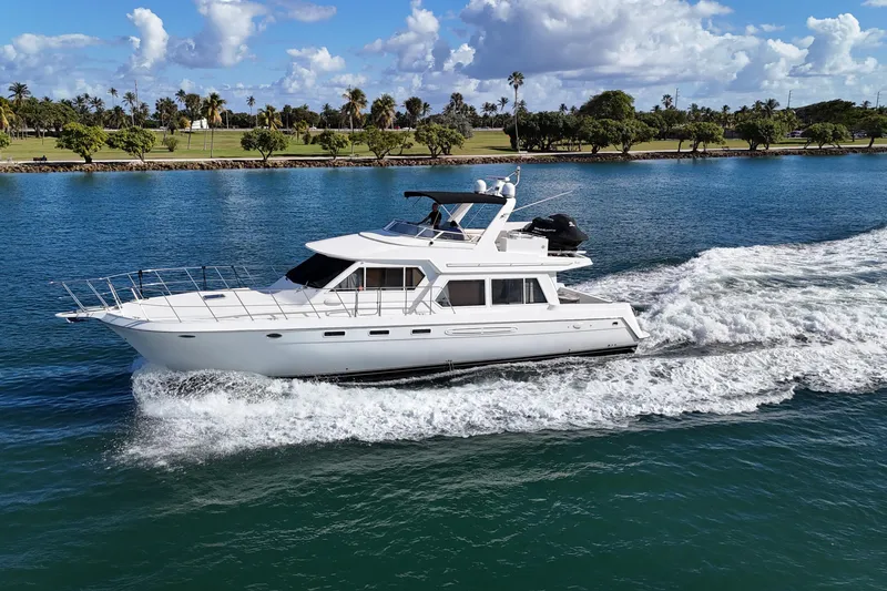 Slide: The Image of 2003 Navigator Rival yacht cruising on a scenic waterway with palm trees in the background. - 4