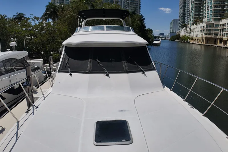Slide: The Image of 2003 Navigator Rival yacht docked by waterfront buildings and lush greenery. - 40