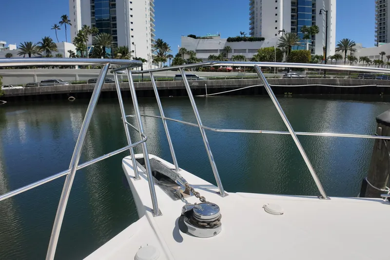 Slide: The Image of Bow of 2003 Navigator Rival yacht docked near waterfront buildings and palm trees. - 41