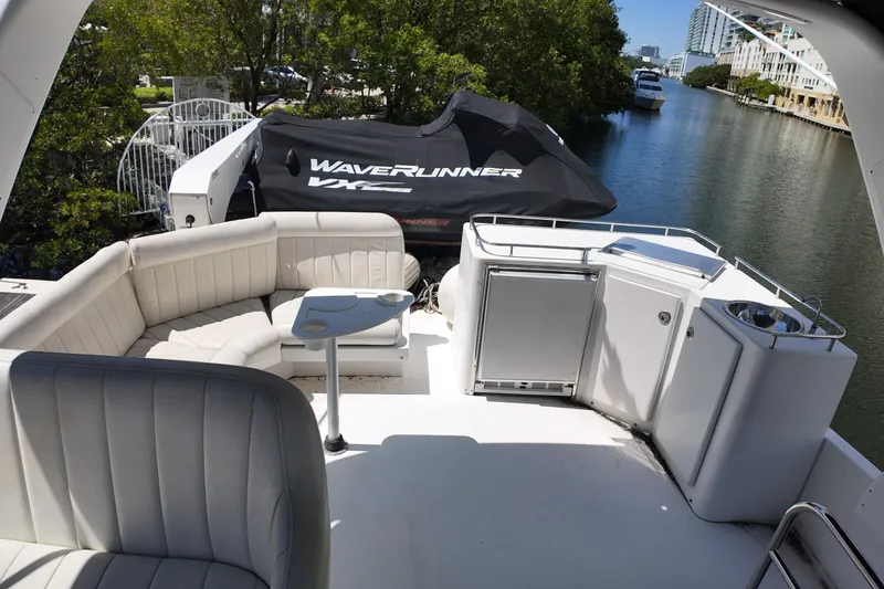 Slide: The Image of 2003 Navigator Rival yacht deck with seating, table, and WaveRunner jet ski on a sunny day. - 5