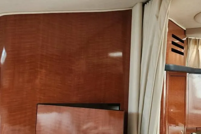 Slide: The Image of Interior of 2002 Sea Ray Sundancer 320 with polished wood paneling and curtains. - 15