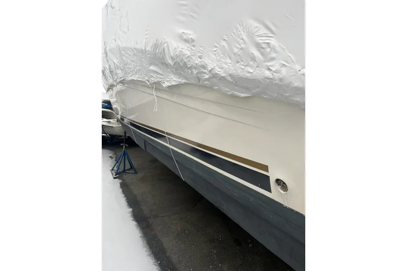 Slide: The Image of 2002 Sea Ray Sundancer 320 boat, partially covered, on a stand in a snowy setting. - 5