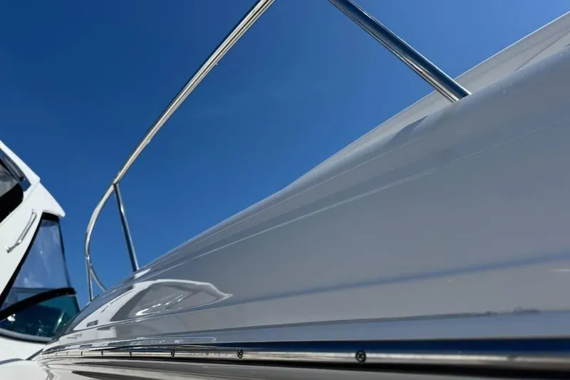 Slide: The Image of 2002 Sea Ray Sundancer 320 yacht, sleek design against clear blue sky. - 7