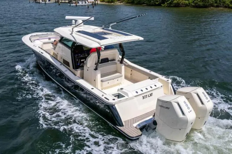 Slide: The Image of Manufacturer Provided Image: 2025 Scout 377 LXF boat cruising on water with dual outboard engines. - 2