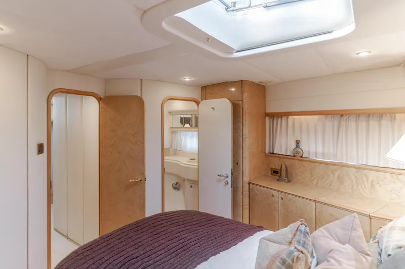 Slide: The Image of Luxurious interior of 1997 Viking Sport Cruisers 66 Motor Yacht bedroom with elegant wood finishes. - 10