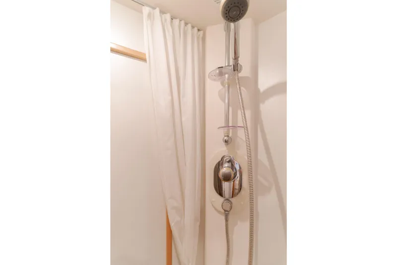 Slide: The Image of Shower area in 1997 Viking Sport Cruisers 66 Motor Yacht with chrome fixtures and white curtain. - 13