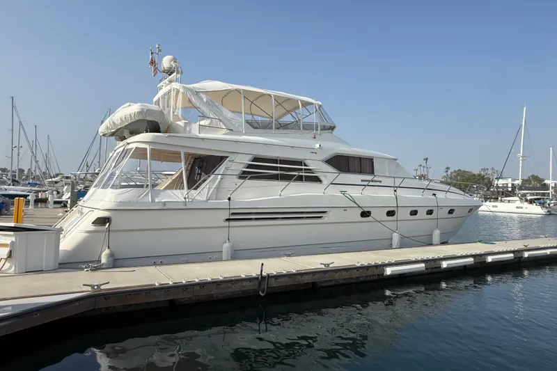 Slide: The Image of 1997 Viking Sport Cruisers 66 Motor Yacht docked at marina under clear blue sky. - 2