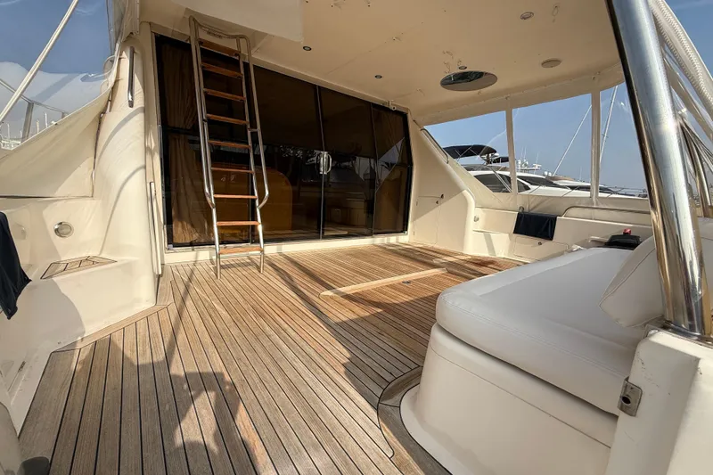 Slide: The Image of Spacious deck of 1997 Viking Sport Cruisers 66 Motor Yacht with wooden flooring and seating. - 3