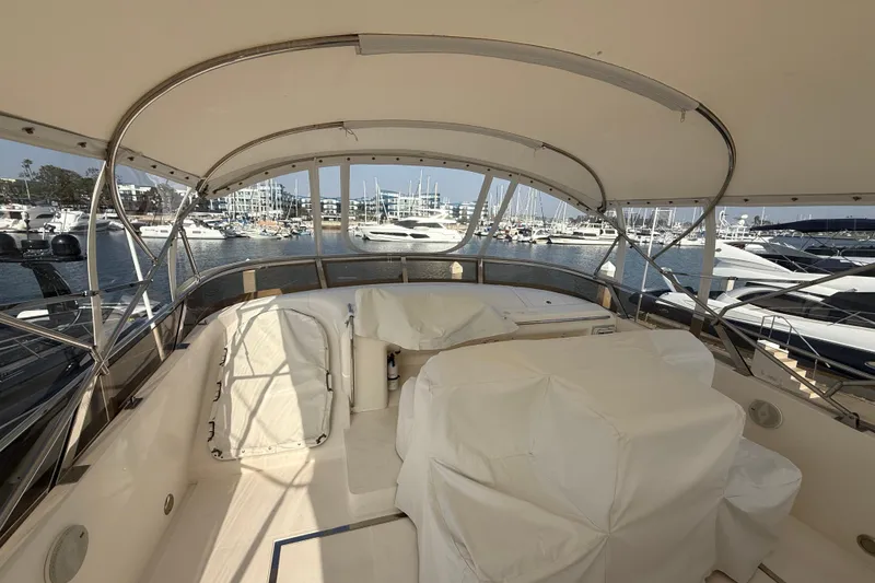 Slide: The Image of 1997 Viking Sport Cruisers 66 Motor Yacht interior with covered seating, docked at marina. - 4