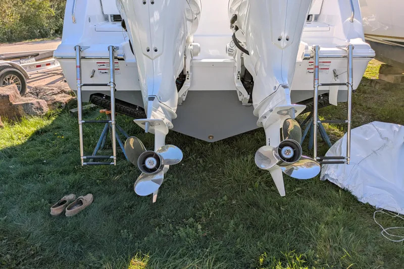 Slide: The Image of 2026 Sportsman Heritage 261 Center Console boat with dual outboard motors on grass. - 5