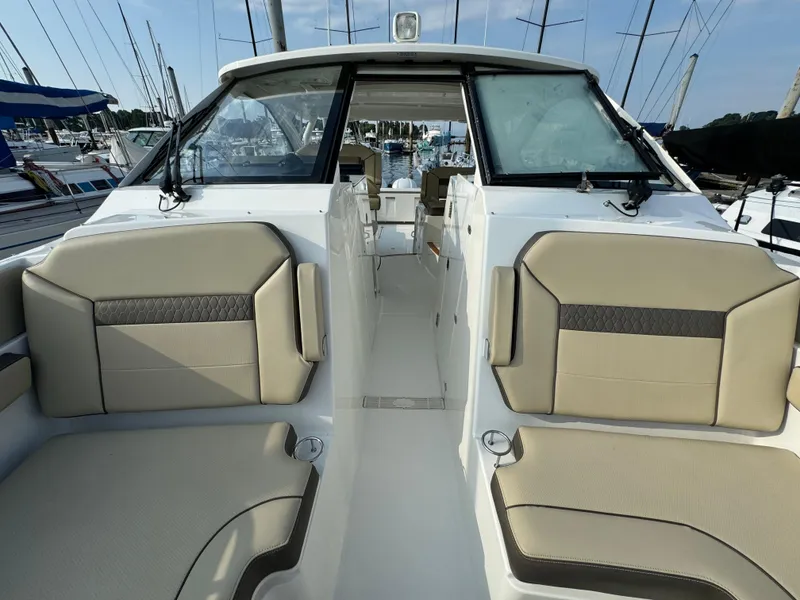Slide: The Image of 2021 Pursuit DC 365 boat interior with beige seating at marina. - 19