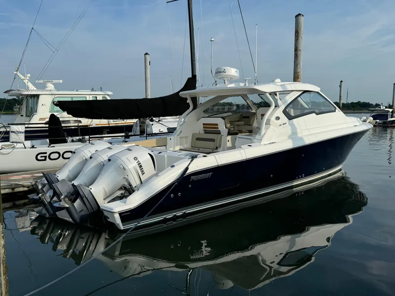 Slide: The Image of 2021 Pursuit DC 365 boat docked in marina with twin Yamaha outboard engines. - 3