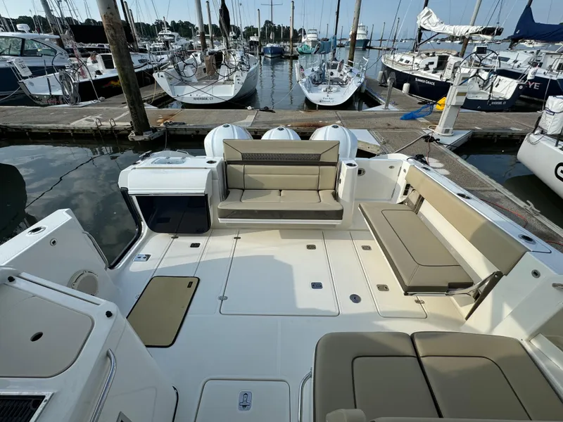 Slide: The Image of 2021 Pursuit DC 365 boat docked at a marina with spacious seating area. - 6