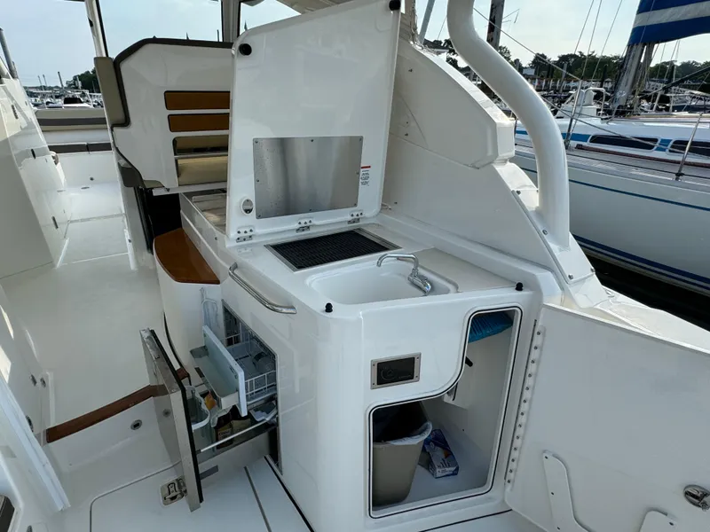 Slide: The Image of 2021 Pursuit DC 365 boat interior with kitchenette and storage compartments. - 7