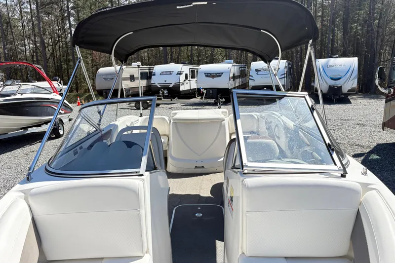 Slide: The Image of 2009 Bayliner 185 Bowrider boat with open cockpit and canopy, parked near RVs. - 9
