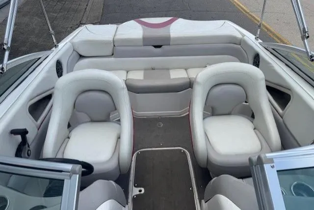 Slide: The Image of Interior of a 2011 Bryant 210 boat with white seating and gray flooring. - 12