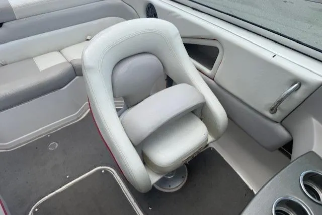 Slide: The Image of Interior of a 2011 Bryant 210 boat featuring a swivel captain's chair and cup holders. - 14
