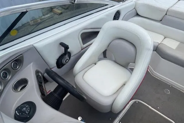 Slide: The Image of Interior of a 2011 Bryant 210 boat featuring white seating and steering controls. - 16