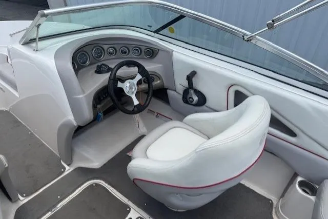 Slide: The Image of Interior of a 2011 Bryant 210 boat featuring a sleek steering wheel and white seating. - 18