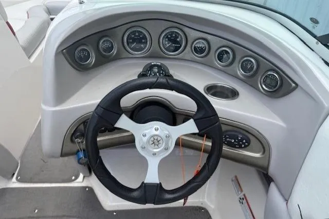Slide: The Image of Steering wheel and dashboard of a 2011 Bryant 210 boat with multiple gauges. - 19