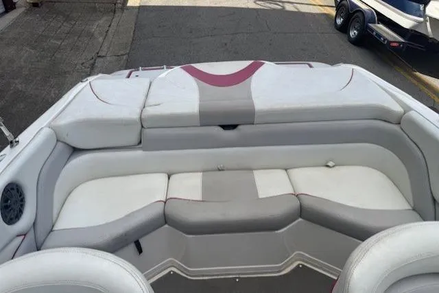 Slide: The Image of 2011 Bryant 210 boat interior with white and gray seating, featuring a rear bench layout. - 20