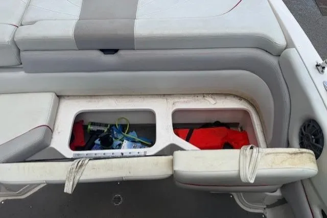 Slide: The Image of Storage compartment in a 2011 Bryant 210 boat with life jackets and accessories. - 21