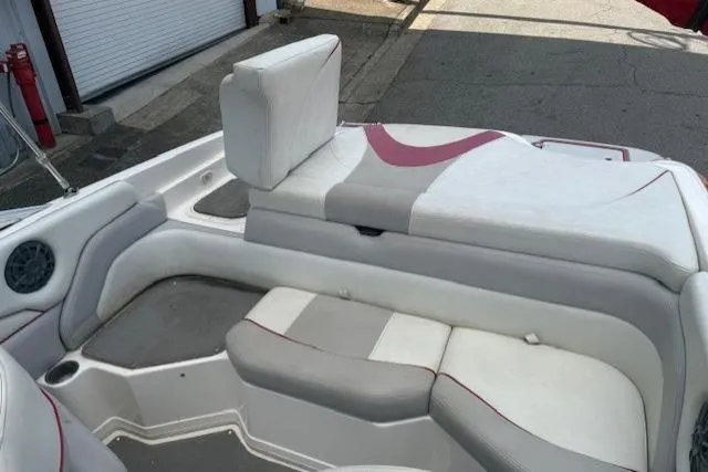 Slide: The Image of 2011 Bryant 210 boat interior with white and gray seating, red accents, and a speaker. - 23