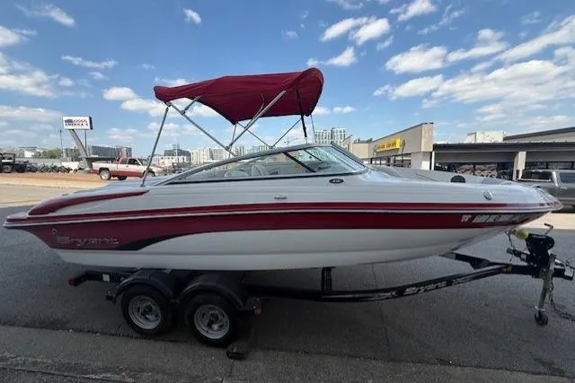 Slide: The Image of Red and white 2011 Bryant 210 boat on trailer, parked outdoors. - 4