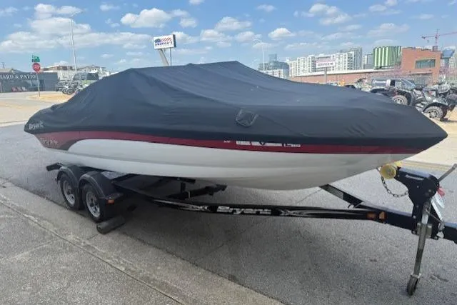 Slide: The Image of 2011 Bryant 210 boat on trailer, covered, parked outdoors. - 8