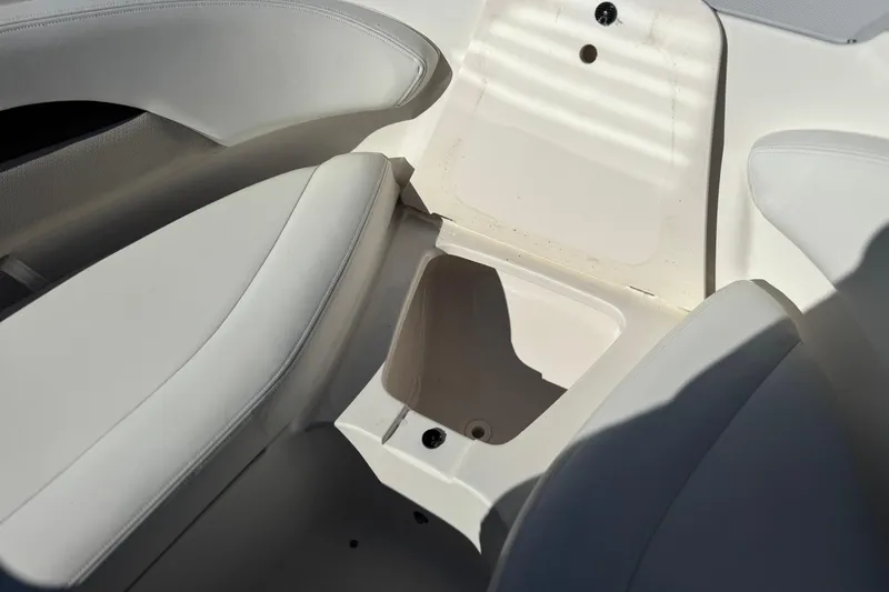 Slide: The Image of Interior storage compartment of 2011 Chaparral 267 SSX boat with white seating. - 17