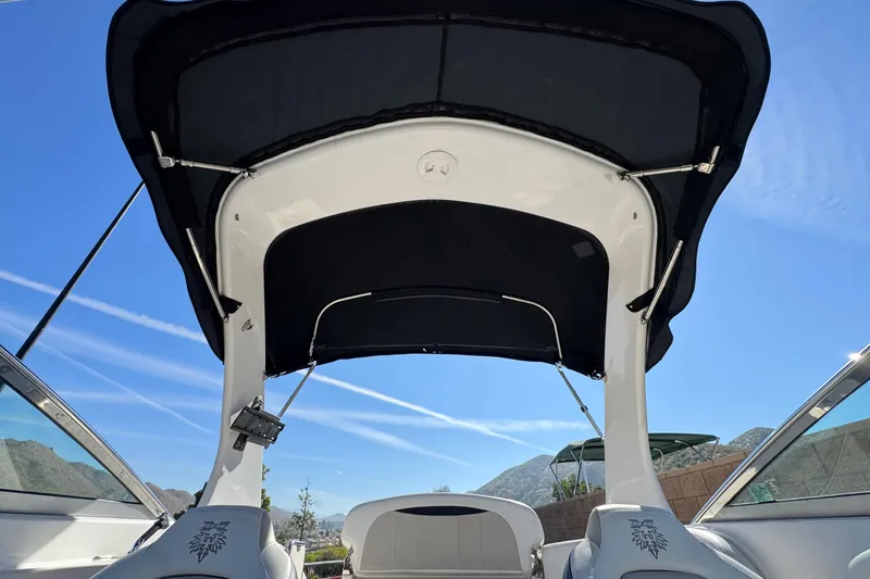 Slide: The Image of 2011 Chaparral 267 SSX boat interior with black canopy against blue sky. - 19