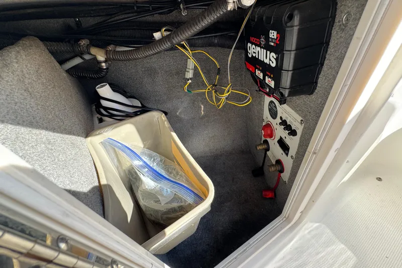 Slide: The Image of Interior view of a 2011 Chaparral 267 SSX boat compartment with wiring and storage. - 26