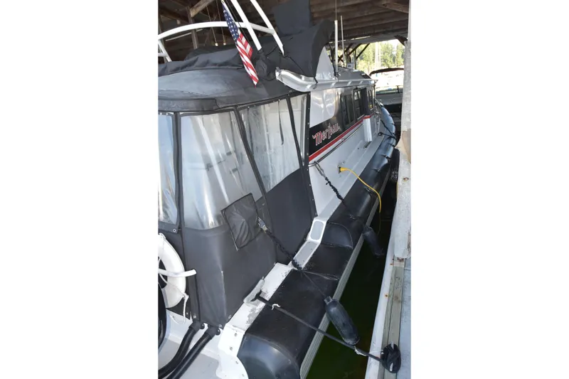 Slide: The Image of 2005 SAFE Boats 33 Full Cabin docked under shelter with American flag. - 15