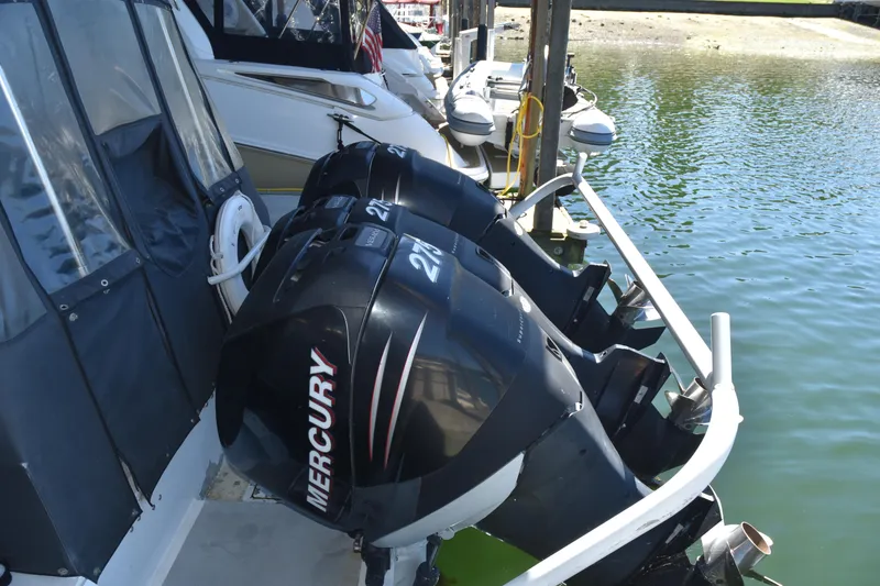 Slide: The Image of SAFE Boats 33 Full Cabin 2005 with Mercury outboard engines docked by water. - 17