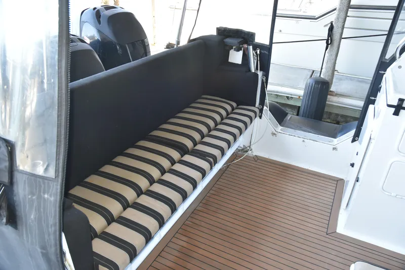 Slide: The Image of Interior of 2005 SAFE Boats 33 Full Cabin with striped seating and wood-patterned flooring. - 19
