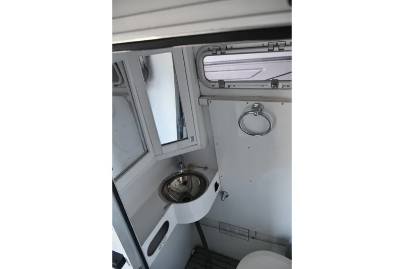 Slide: The Image of Interior of 2005 SAFE Boats 33 Full Cabin, featuring compact bathroom with sink and mirror. - 39