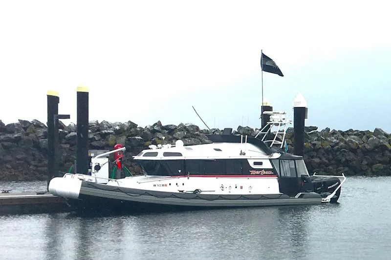 Slide: The Image of 2005 SAFE Boats 33 Full Cabin docked at a marina with rocky background. - 4