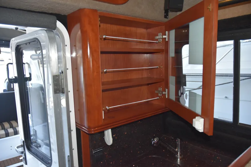 Slide: The Image of Interior of 2005 SAFE Boats 33 Full Cabin with open wooden cabinet and sink. - 50