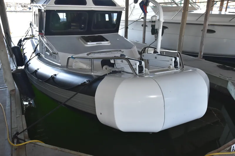 Slide: The Image of 2005 SAFE Boats 33 Full Cabin docked, featuring robust design and protective fenders. - 6