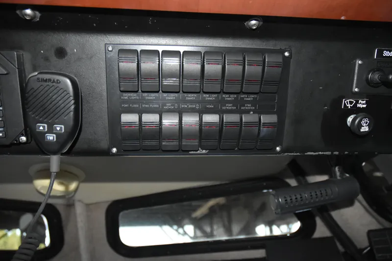 Slide: The Image of Control panel of a 2005 SAFE Boats 33 Full Cabin with switches and Simrad microphone. - 74