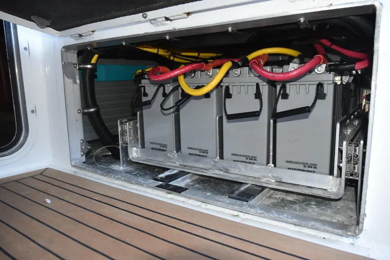 Slide: The Image of Battery compartment of a 2005 SAFE Boats 33 Full Cabin, featuring multiple connected batteries. - 79