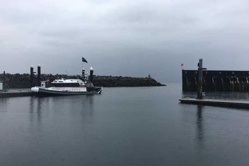 Slide: The Image of SAFE Boats 33 Full Cabin, 2005 model, docked in a calm harbor under overcast skies. - 80