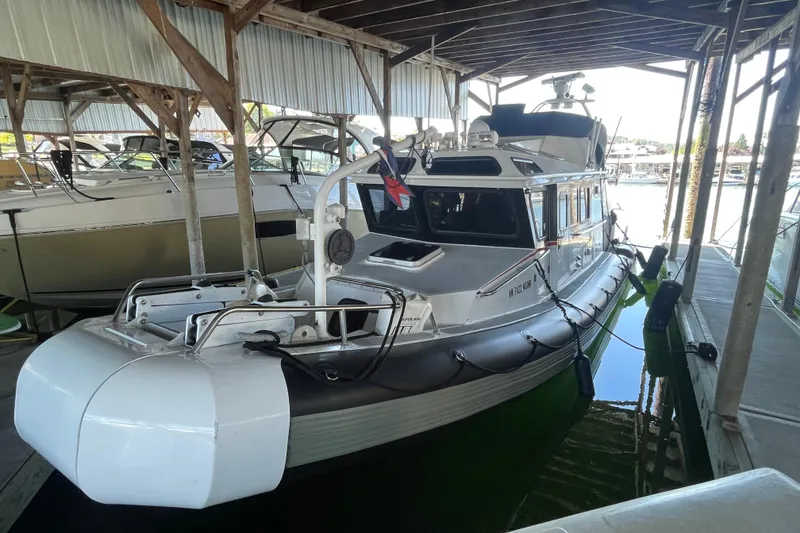 Slide: The Image of 2005 SAFE Boats 33 Full Cabin docked under shelter. - 82