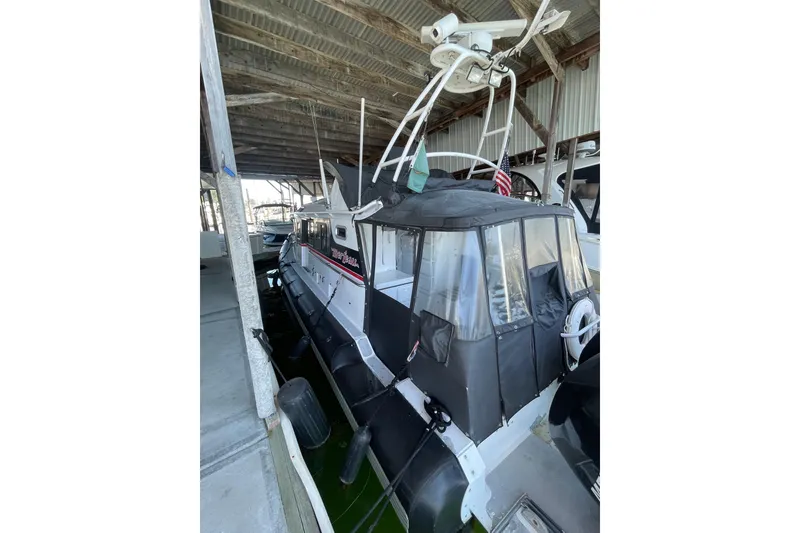 Slide: The Image of 2005 SAFE Boats 33 Full Cabin docked under shelter, featuring protective canopy and radar equipment. - 83