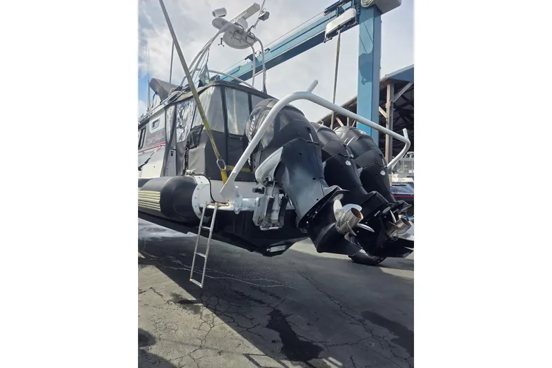 Slide: The Image of SAFE Boats 33 Full Cabin 2005 with dual outboard motors in a boatyard. - 84