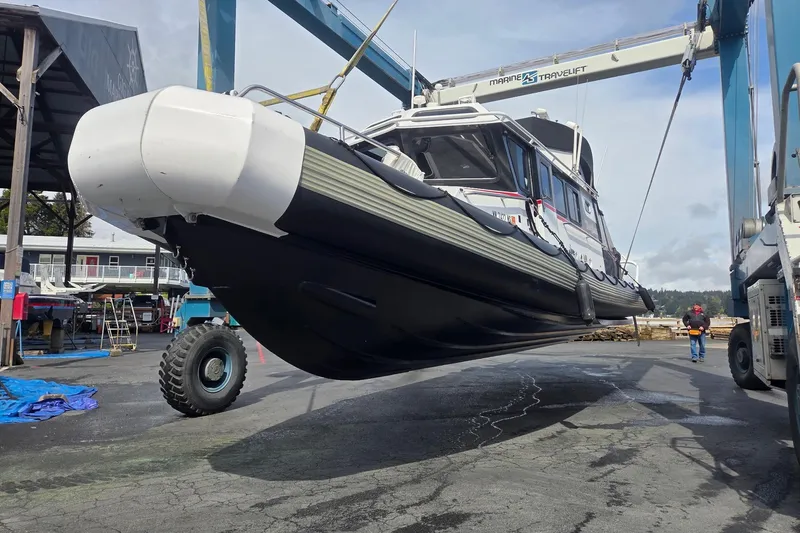 Slide: The Image of SAFE Boats 33 Full Cabin 2005 lifted by Marine Travelift at a boatyard. - 85