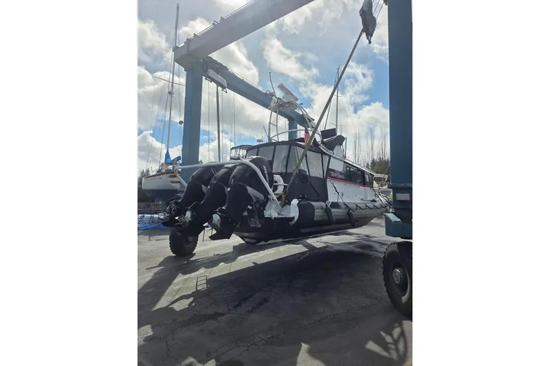 Slide: The Image of 2005 SAFE Boats 33 Full Cabin lifted by crane, showcasing powerful engines and sturdy design. - 86