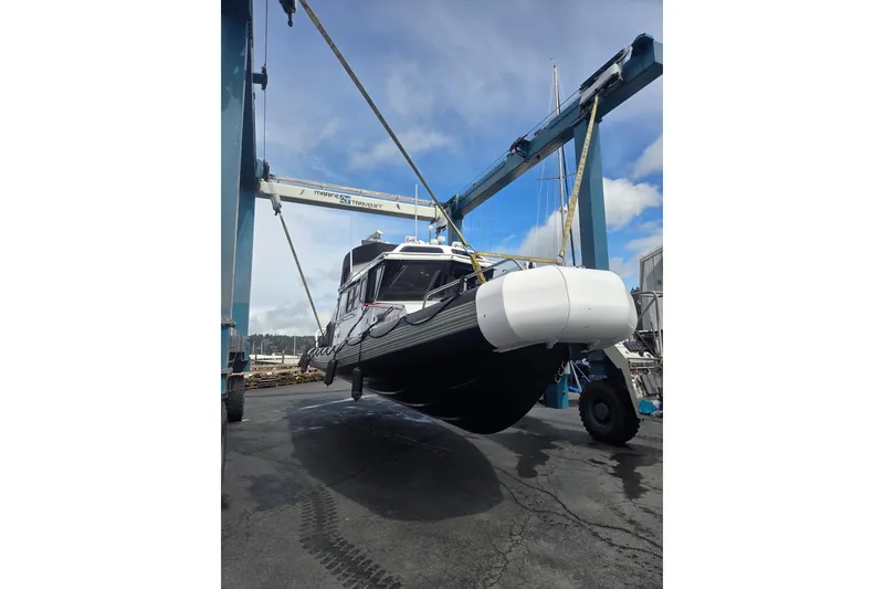 Slide: The Image of SAFE Boats 33 Full Cabin 2005 being lifted by a crane at a marina. - 87